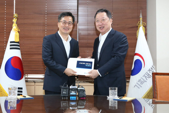 15일 정부서울청사에서 박용만 대한상공회의소 회장(오른쪽)이 김동연 경제부총리에게 '규제개혁 프로세스 개선방안' 보고서를 전달하고 있다. 이 보고서에는 규제 개혁의 '로드 블록'(장애물)을 제거하기 위해 '규제개혁 튜브'를 구축하고 전문가 기구와 공론화 기구로 이원화 해 규제개혁 해법을 논의하자는 내용이 담겨있다. <대한상공회의소 제공>